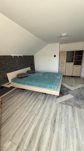 a bedroom with a bed in a room with wooden floors at Piatra Craiului Retreat in Zărneşti