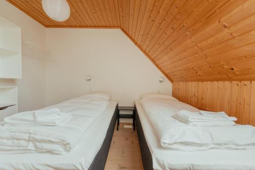 two beds in a small room with wooden ceilings at 3BR House in Tórshavn - Quiet Street - Parking in Tórshavn
