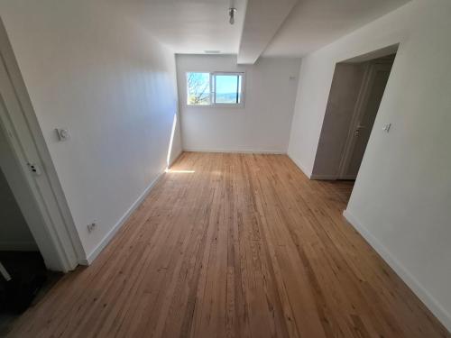 an empty room with a wooden floor and a window at Gîte du Petit Guilhem in Montaut-les-Crénaux