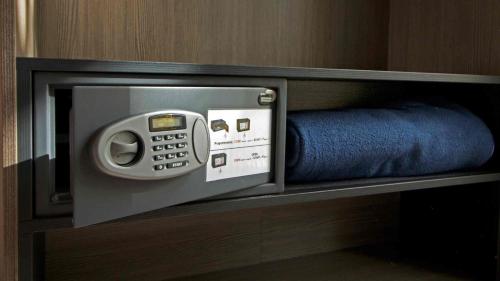 a microwave oven with a phone in a room at Le Strasbourg Hotel in Montpellier