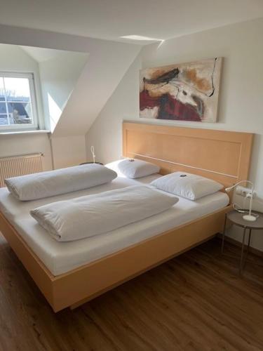 a bed with two pillows on it in a bedroom at "NEU" Apartments-Hotel Huberhof Allershausen in Allershausen