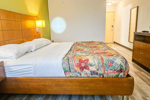 a bedroom with a large bed with a wooden headboard at Jackson Hotel And Convention Center in Jackson