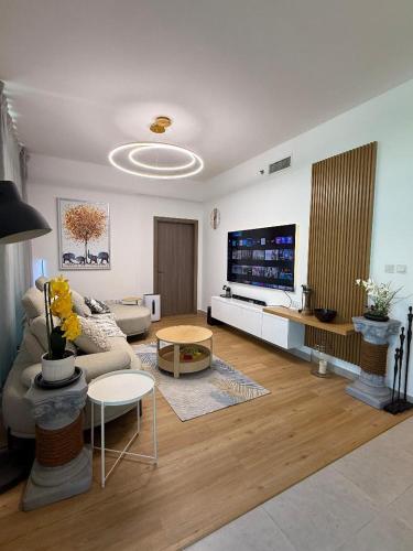 a living room with a couch and a tv at Luxury 1BR Apartment in NYU Saadiyat - Furnished in Abu Dhabi
