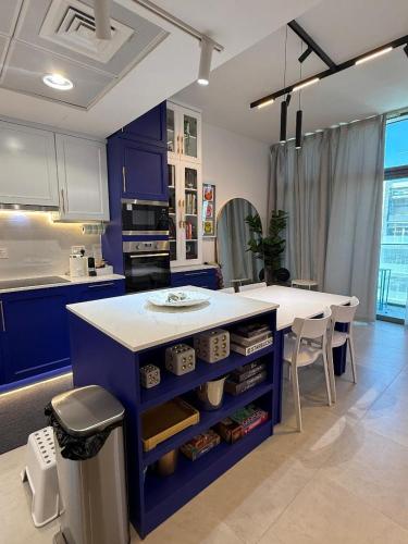 a kitchen with blue cabinets and a white counter at Luxury 1BR Apartment in NYU Saadiyat - Furnished in Abu Dhabi
