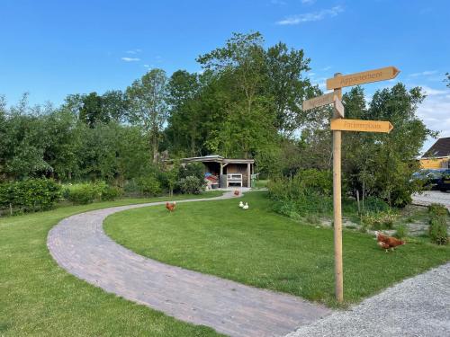a wooden sign with two arrows on a road at Bed and Breakfast de Salix in Hitzum