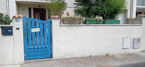 a blue door on the side of a white wall at Logement dans résidence principale Le Crès in Le Crès