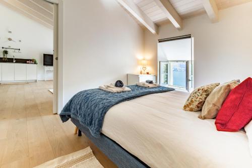 a bedroom with a large bed and a large window at Magnificent apartment on Lake Lugano, Morcote in Morcote