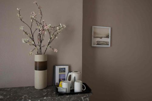 - une table avec un vase et des fleurs dans la chambre dans l'établissement Le Strasbourg Hotel, à Montpellier