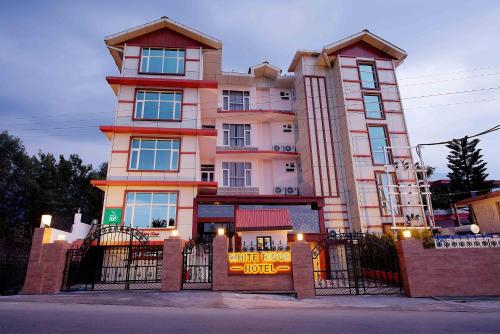 a tall building with a sign in front of it at White Ridge Hotel in Dharamshala
