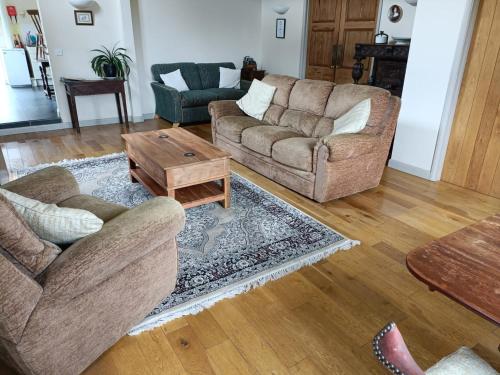 a living room with two couches and a coffee table at Pandy Barn Berriew in Welshpool