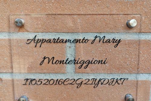 a sign on the side of a brick building at Appartamento Mary Monteriggioni in Monteriggioni
