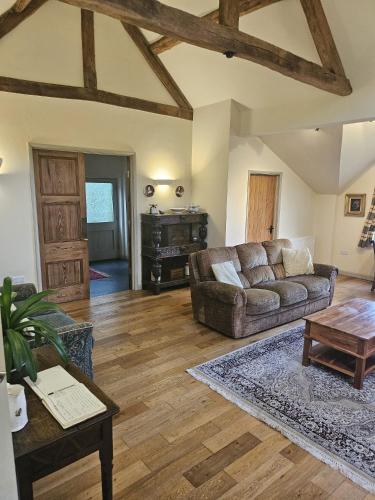 a living room with a couch and a table at Pandy Barn Berriew in Welshpool