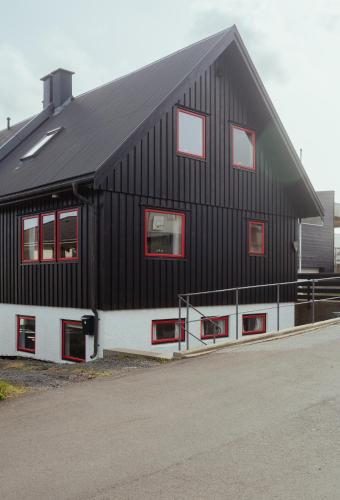 a black and white building with red windows at 3BR House in Tórshavn - Quiet Street - Parking in Tórshavn