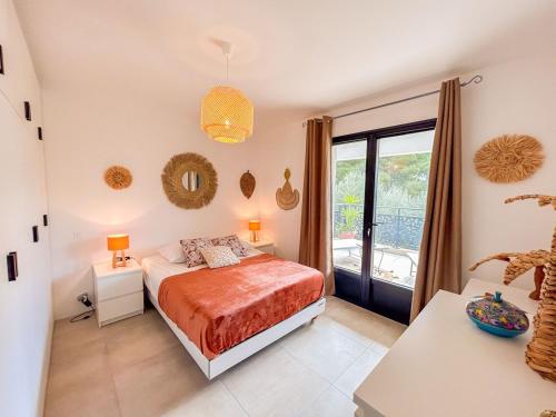 une chambre avec un lit et une grande fenêtre dans l'établissement Joli T2 avec terrasse à Bandol, à Bandol