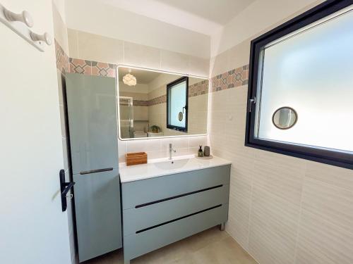 une salle de bain avec un lavabo et un miroir dans l'établissement Joli T2 avec terrasse à Bandol, à Bandol