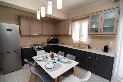 a kitchen with a table and chairs and a refrigerator at Ohana - 10 min to beach in Kos Town