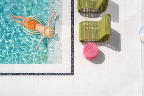 a person swimming in a swimming pool with a float in the water at Maldives Beach Resort in Chao Lao Beach