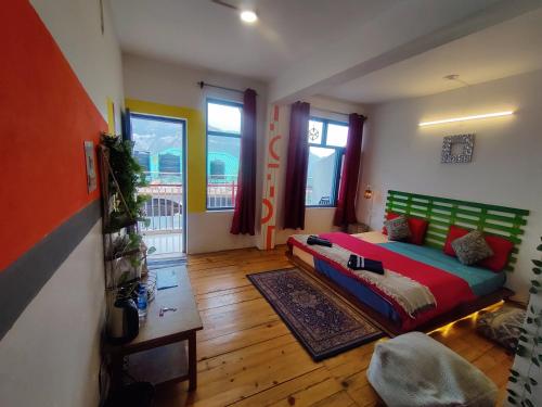 a bedroom with a bed in a room with wooden floors at Mitra Mcleodganj in McLeod Ganj