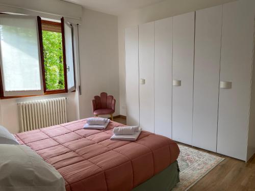 a bedroom with a bed with a pink blanket at La Chiocciola Viaggiatrice in Palazzolo sullʼOglio