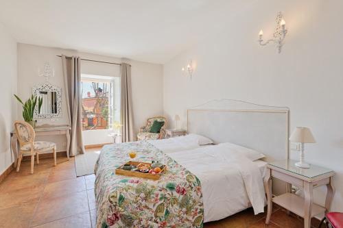 a bedroom with a bed with a tray of fruit on it at Hostellerie du Cigalou in Bormes-les-Mimosas