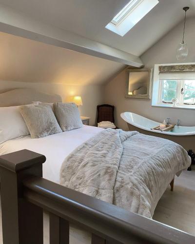 ein Schlafzimmer mit großem Bett und Badewanne in der Unterkunft Cedar Cottage newly renovated cottage in Matlock