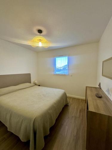une chambre avec un grand lit et une fenêtre dans l'établissement Appartement neuf confortable, à LʼÎle-Rousse
