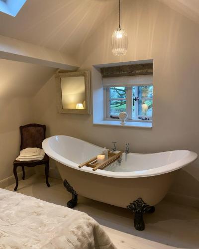a large bath tub in a bathroom with a window at Cedar Cottage newly renovated cottage in Matlock
