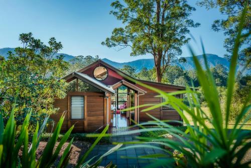 a cabin in the woods with mountains in the background at Promised Land Retreat in Bellingen