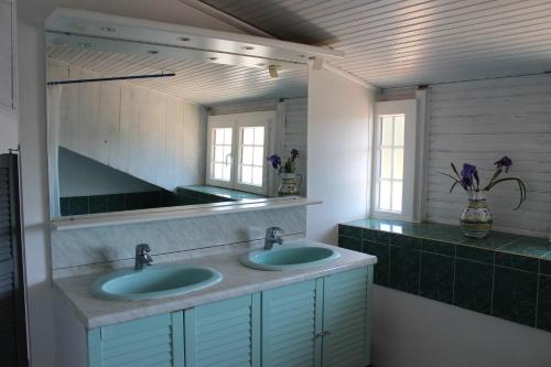 une salle de bain avec deux lavabos et un miroir dans l'établissement Villa Palmera, à Anglet