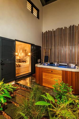a bathroom with a tub in a room with a bed at Villa Kintana - Piscine - SPA - Prestations 5 Etoiles in Petite Île