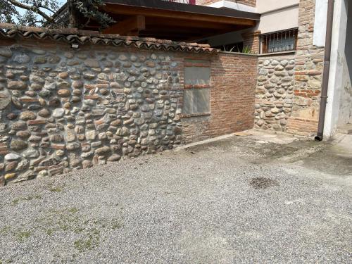 a brick building with a stone wall with a window at La Chiocciola Viaggiatrice in Palazzolo sullʼOglio