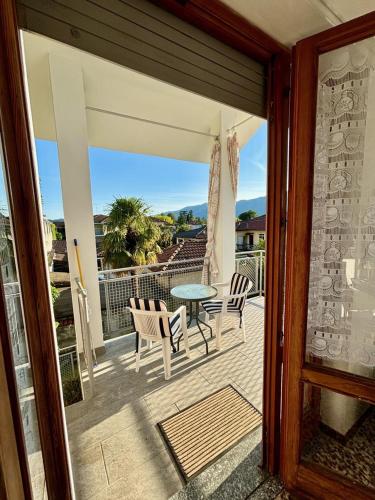 a patio with a table and chairs on a balcony at Guest House le Palme in Orta San Giulio