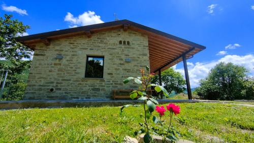a small stone building in a field with a flower at Agriturismo Foglie in Gubbio