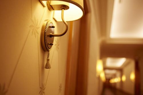 a lamp is hanging on a wall next to a door at Imperial Hotel Osaka in Osaka