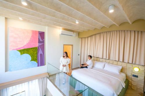 a couple in a hotel room with a bed at Maldives Beach Resort in Chao Lao Beach