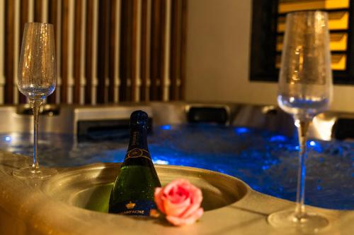 a bottle of champagne in a table with two wine glasses at Villa Kintana - Piscine - SPA - Prestations 5 Etoiles in Petite Île
