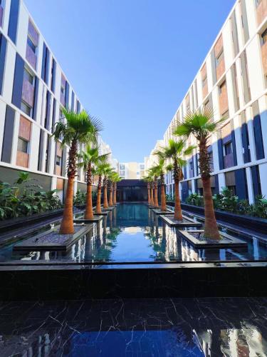 a row of palm trees in front of a building at Only You in Sidi Daoud