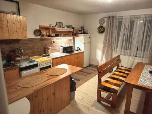 a kitchen with wooden cabinets and a wooden table with a dining table at Chata na hradzi in Lekárt