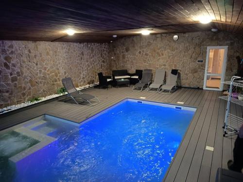 a large swimming pool in a room with a table and chairs at Chata na hradzi in Lekárt