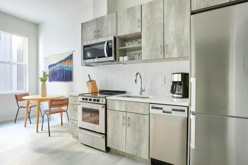 a kitchen with stainless steel appliances and a table at Sonder by Marriott Bonvoy Zuni Apartments LoHi in Denver