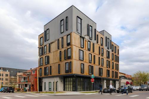 a tall building on a city street with people walking past it at The Artesian in Denver