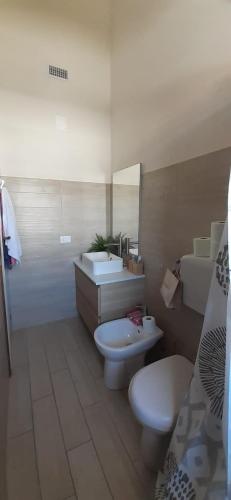 a bathroom with two toilets and a sink and a mirror at Villa Manuela in Silvi Marina