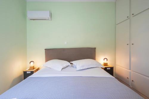 a bedroom with a bed with two pillows and two lamps at Aris123 by Smart Cozy Suites - Apartments in the heart of Athens - 5 minutes from metro - Available 24hr in Athens