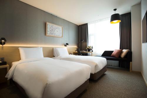 a hotel room with two beds and a window at Arirang Hill Hotel Dongdaemun in Seoul