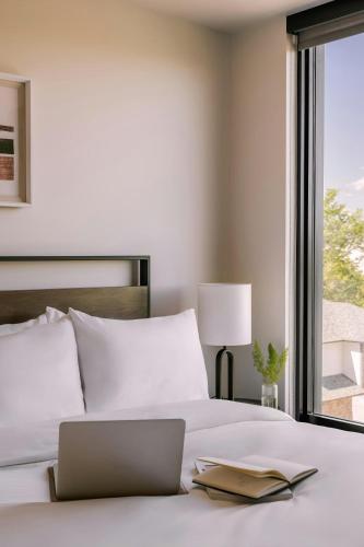 a laptop on a bed with a book on it at Bryant, Sonder Apartment by Marriott Bonvoy in Denver