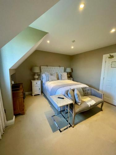 a bedroom with a large bed and a couch at The Shores Country House in Castlegregory