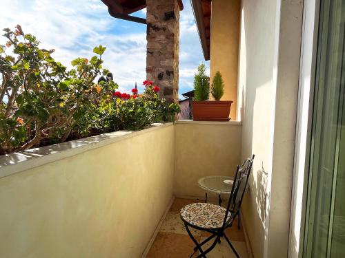 a small balcony with a table and chairs and flowers at La Collina delle Acacie in Grumolo Pedemonte