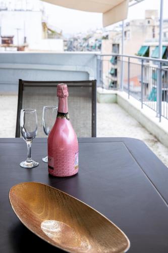 a bottle of wine sitting on a table with two glasses at Aris123 by Smart Cozy Suites - Apartments in the heart of Athens - 5 minutes from metro - Available 24hr in Athens