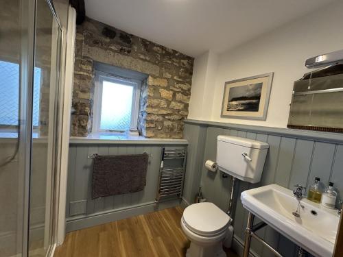 a bathroom with a toilet and a sink and a window at Ryedale Cottage in Helmsley