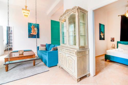 een woonkamer met een blauwe bank en een grootvaderklok bij Neoclassical Loft in Monastiraki - Acropolis and metro in Athene